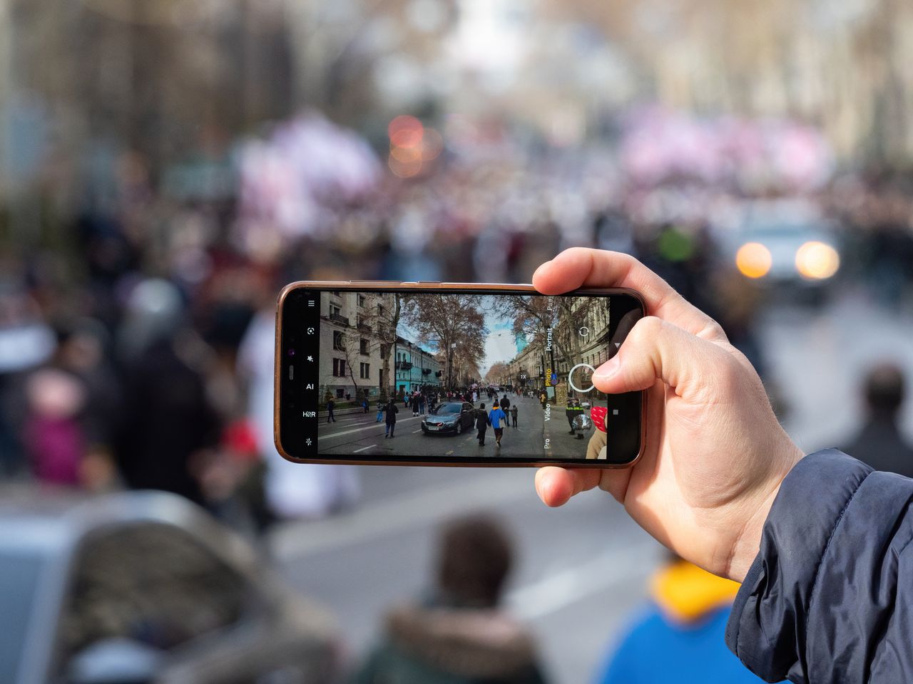 街頭でスマートフォンを掲げ、通行人が写り込む様子を撮影する人物